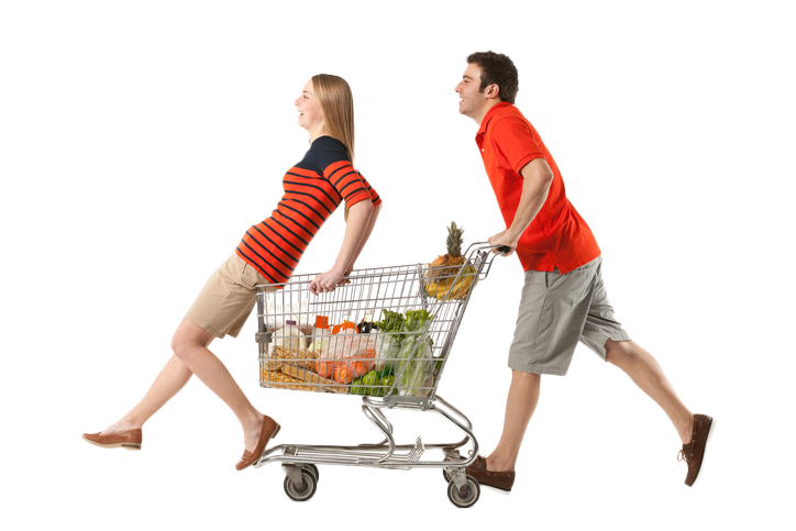 Man pushing a full grocery shopping cart with woman riding on the front.